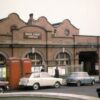 1963年のムーア・ストリート駅。赤レンガの駅舎とクラシックカーが並ぶ英国バーミンガムの街角。