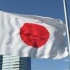 青空に掲げられた日本国旗（日の丸）。白地に赤い円が描かれた、太陽を象徴する国家のシンボル。