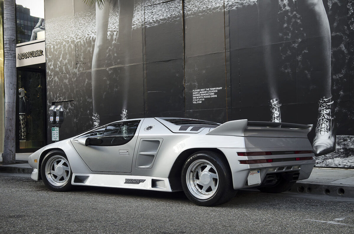 都市の壁画を背景に停車するVector W8