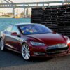 テスラ・モデルS（初期型）バーガンディレッド、港湾を背景に撮影