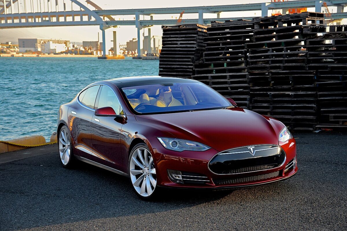 テスラ・モデルS（初期型）バーガンディレッド、港湾を背景に撮影